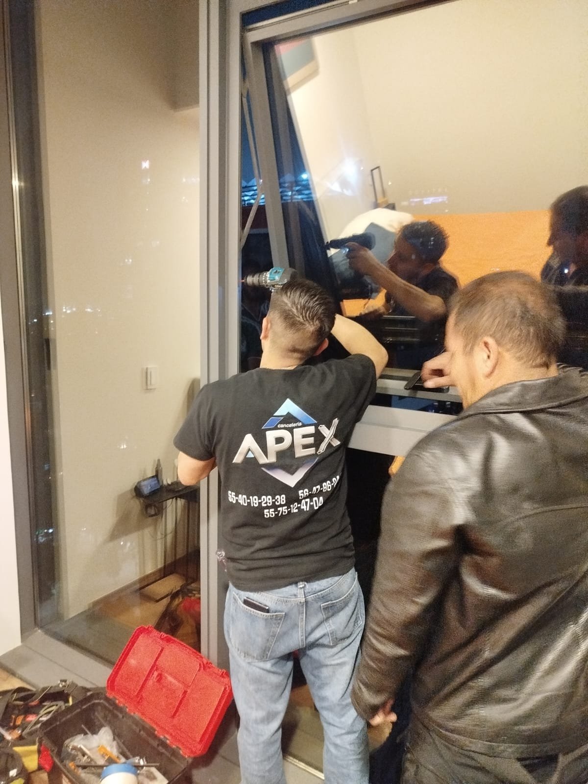 Técnico de APEX ajustando compases de ventana proyectable de aluminio